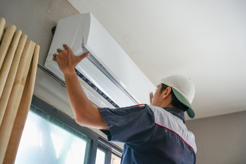 Licensed AC installation technician fitting a new air conditioning unit in Abu Dhabi