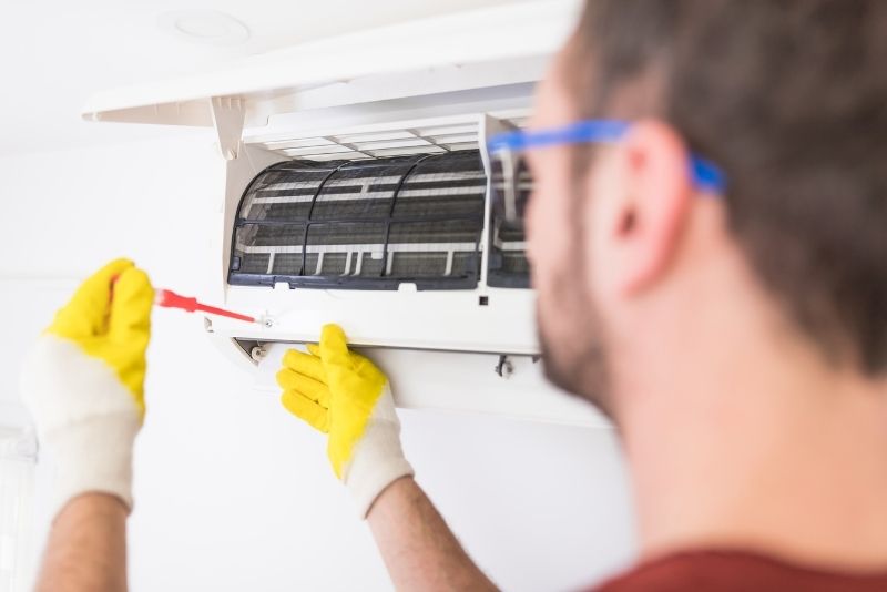 Certified AC maintenance technician servicing an air conditioning unit in Abu Dhabi